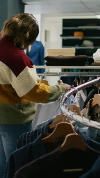 Вертикальне Відео Сучасний Клієнт Дивиться Сорочки Висять Магазині Одягу Молода — стокове відео