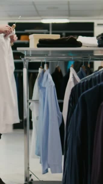 Vertikální Video Mužský Zákazník Analyzuje Módní Kolekci Butiku Formální Oblečení — Stock video
