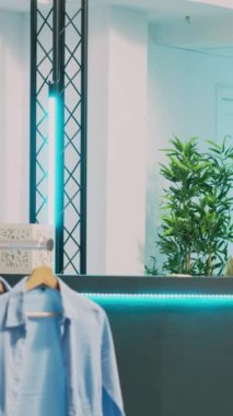 Dikey video: Asyalı biri butik dükkanından moda koleksiyonu alıyor, pos terminalinde elektronik ödeme yapıyor. İşlemden önce kasada çalışan bir mağazayla konuşan genç bir müşteri.