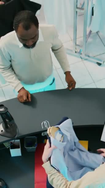 Вертикальное Видео Афроамериканец Покупает Одежду Помощью Карты Расплачиваясь Терминале Магазине — стоковое видео
