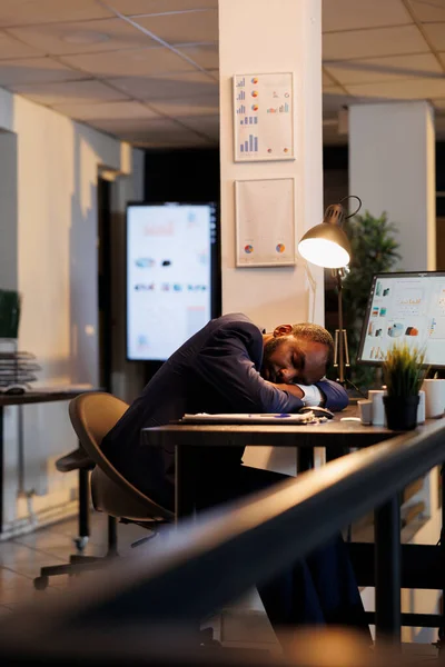 財務報告を終えた後は スタートアップオフィスのテーブルに寝たきりの勤勉な従業員 会社の投資戦略を計画し ワークスペースで残業を働く仕事中毒の経営者 — ストック写真