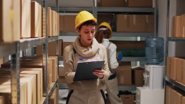 Vrouwelijke Werknemer Controleren Van Lijst Van Goederen Papier Met Behulp — Stockvideo