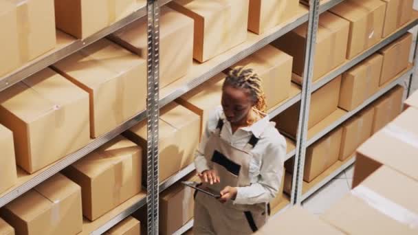 Tulumlu Afro Amerikalı Kız Dijital Tabletle Çalışıyor Paketlerdeki Endüstriyel Ürünlere — Stok video