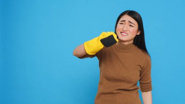 Profesyonel temizlikçi, her yüzeyin temiz ve hijyenik olmasını sağlarken sünger kullanarak yoğun temizlik yapıyor. Asyalı temizlikçi, oda temizliği ve stüdyo çekimlerinde yetenekliydi.