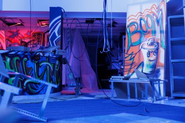 Yıkılmış yapı toza dönüştü ve parlak neon ışıklarla parladı. Kentin varoş bölgesinde kirli görünüyordu. Grafiti sanatı ve floresan mor ışıkla dolu boş bir depo..