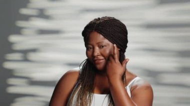 Genç kusursuz model kamerada zarif jestler yapıyor. Kozmetik kampanyası için reklam kurulunu kabul ediyor. Neşeli pozitif kadın kusurları kucaklıyor, parlayan doğal güzellik.