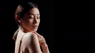 Flawless young woman applying cream on shoulders to promote uplifting campaign, using sunscreen or moisturizing serum for skincare ad. Girl with radiant skin using dermatology products.