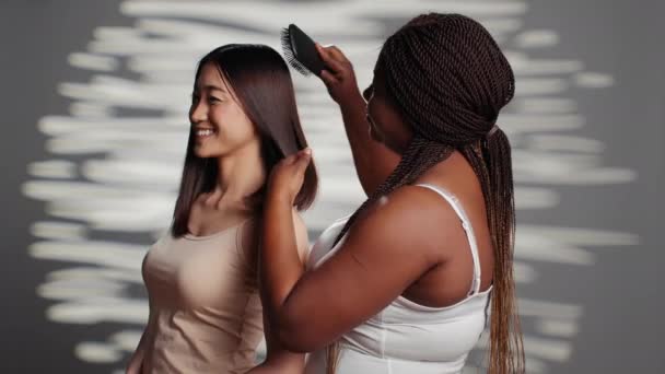 African American Girl Brushing Hair Asian Friend Camera Posing Promote — Stock Video