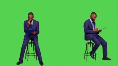 Afrika kökenli Amerikalı bir adam kağıtlar üzerine iş notları düşünüyor. Pano dosyaları üzerine yeni fikirler üretiyor. Stüdyoda sandalyede oturan genç iş adamı, düşünceli ve düşünceli..