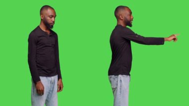 Afro-Amerikalı bir adam hayal kırıklığına uğramış gibi davranıp bir şey düşürdüğünü söylüyor, yeşil perde arkaplanı. Stüdyoda kendini rahatsız ve kendinden emin hisseden bir genç..