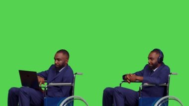 İşadamı dizüstü bilgisayar kullanıyor ve stüdyoda müzik dinliyor. Tekerlekli sandalye kullanıcısı. Kronik özürlü genç adam bilgisayarda çalışıyor, kulaklıkla şarkı söylemenin tadını çıkarıyor. Yeşil Ekran.