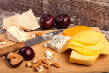 Fındık, peynir ve meyve studio fotoğraf ahşap arka plan üzerinde