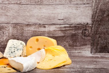 Ahşap arka planda farklı bir peynir türü. Gurme yemek aperatifi