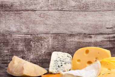 Ahşap arka planda farklı bir peynir türü. Gurme yemek aperatifi