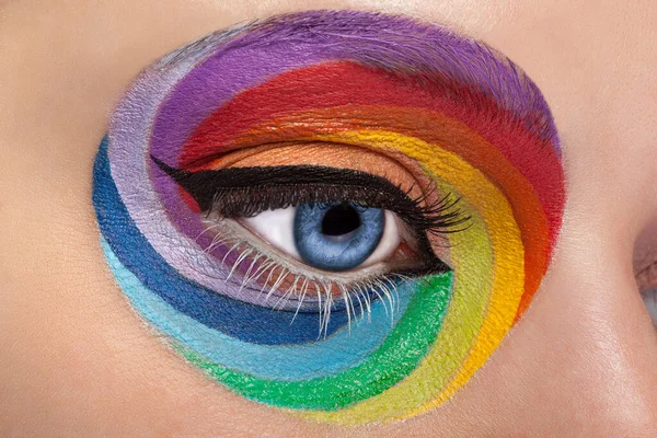 Close up blue eye with artistic rainbow make up. Colors and colorful. Joy. Artistic and fashion make up. Make up addiction. Cosmetics. On stage make up