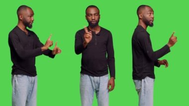 Afrikalı Amerikalı bir adam parmaklarıyla hiçbir sembol göstermiyor. Stüdyoda reddetme ve reddetme hareketi yapıyor. Genç erkek model yeşil perde arkaplanını onaylamadığını ve reddettiğini ifade ediyor..
