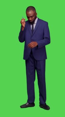 Dikey video: Stüdyoda yeni fikirler üreten, takım elbise giyen ve önemli başlangıç bilgilerini düşünen düşünceli bir resmi şahsın ön görüntüsü. Düşünceli girişimci.