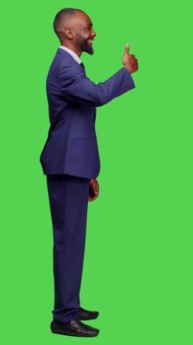 Dikey video: Gülümseyen başlangıç çalışanı profili başparmak işareti gösteriyor ve stüdyo, tam vücut yeşil ekranda onay veriyor. Aşındırıcı yönetici kendinden emin ve pozitif hissediyor.