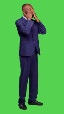 Dikey video: Afro-Amerikan işçilerin kavga edişinin ve kamera önünde tartışmalarının yan görüntüsü, tüm yeşil ekran karşısında hoşnutsuz ve öfkeli hissetmeleri. Anlaşmazlık içindeki genç iş adamı