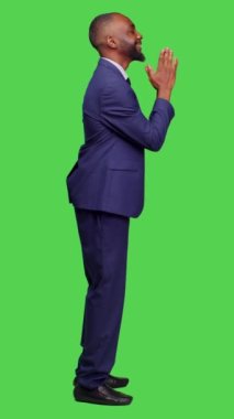 Dikey video: Afro-Amerikan bir adamın dua eden elleri simgelediği ve kamera önünde af dilediği profil, ruhani bir jest. Erkek girişimci iyi şans ve iyimser olmak için Tanrı 'ya dua ediyor.