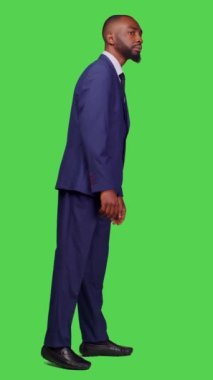 Dikey video: Afrikalı Amerikalı iş adamının profili stüdyoya bakıyor, bir şeyler bekliyor ve ofis kıyafeti giyiyor. Resmi başlangıç çalışanı tüm vücudun üzerinde kendine güveniyormuş gibi davranıyor
