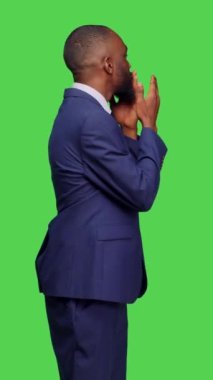 Dikey video: Modern çalışanın stüdyoya hava öpücüğü göndermesi ve romantik jestler yapması, kamerada iyimser ve pozitif hissetmesi. Genç yetişkin yeşil perde arkaplanı üzerinde öpüşüyor.