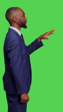 Dikey video: Stüdyoda 3 boyutlu holografik görüntüyü inceleyen şirket yöneticisinin profili, hologramlar ve yapay zekayla çalışıyor. Ofis kıyafeti giyen genç bir adam, holografla arttırılmış...