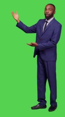 Dikey video: Ofis kıyafetli işadamının yan görüntüsü kameraya yan bakıyor, tüm gövde üzerinde kurumsal sunum yaratıyor. Genç erkek çalışanın reklamı var.