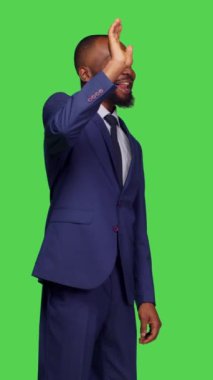 Dikey video: Çevrimiçi video konuşmasında konuşan Afro-Amerikan 'ın yeşil ekran arka planının, telekonferansın üzerinde duran görüntüsü. Uzaktan görüntülü konferans sohbetini kullanan takım elbiseli iş adamı, kendinden emin