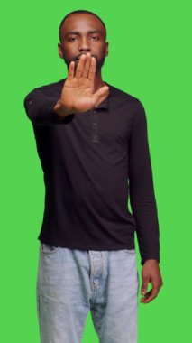 Dikey video: Negatif yetişkinlerin kamera önünde avuç içi göstermemesi, stüdyoda yeşil ekranda reddedildiğini gösteriyor. Erkek model olumsuz tepki veriyor, onaylamıyor.