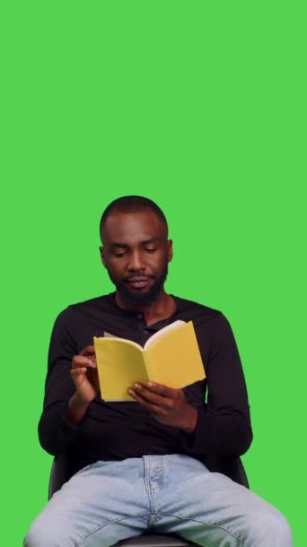 Pionowe Wideo Widok Przodu Afrikańskiego Amerykanina Urzeczony Powieścią Czytającego Książkę — Wideo stockowe