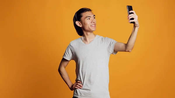 快乐的男人拍照片 表现得无忧无虑 微笑着 在手机上摆姿势拍照 年轻快乐的模特儿在智能手机上拍照 在社交媒体上张贴照片 嬉皮士的模样 — 图库照片