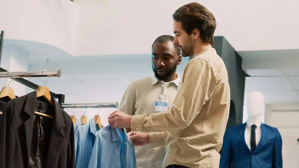 Pracownik Centrum Handlowego Pomaga Klientowi Zakupach Nowoczesnych Ubrań Sklepie Odzieżowym — Zdjęcie stockowe