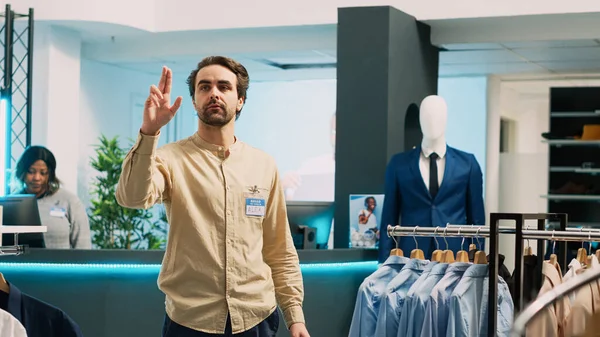衣料品店アシスタントチェック在庫上のホログラム 作業ショッピングセンターで人工知能と拡張現実 ホログラフィック画像 中小企業のコンセプトを使用して若い従業員 — ストック写真