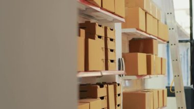 Ambar ve raflardaki karton kutularla dolu boş bir depo. Depodaki eşyalar ve kargo paketleri. Malları konteynırlarda, ürünleri de depolarda üretiyorlar..