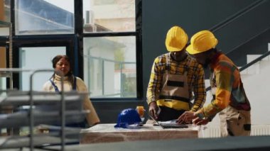 Depo malzemeleri ve stok ürünleri için dizüstü bilgisayar kullanan bir ekip. Raflarda kutular ve paketlerle ürün dağılımı üzerinde çalışmak, kalite kontrolü.