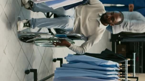 Dikey Video Genç Yetişkin Tekerlekli Sandalye Kullanıcısı Mağazadan Modern Kıyafetler — Stok video