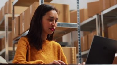 PC 'ye sipariş teslimatı yapmayı planlayan kadın girişimciler paket göndermeden önce ürünlerin lojistiğini analiz ediyorlar. Envanter ve küçük işletme planı için dizüstü bilgisayarla çalışan genç bir kadın. El kamerasıyla..