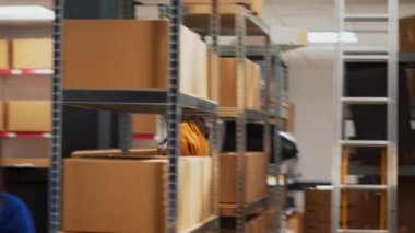 Sipariş yönetimi için ürün göndermek üzere paketlerdeki malları kontrol eden bir grup işçi. Depodaki küçük işletmeler için finansal planlama yapmak için takım halinde çalışan Asyalılar. El kamerasıyla..