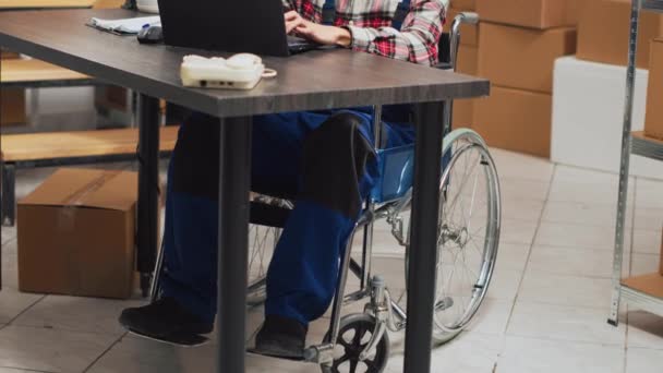 Людина Хронічною Інвалідністю Використовує Ноутбук Складі Перевіряючи Запаси Товарів Логістики — стокове відео