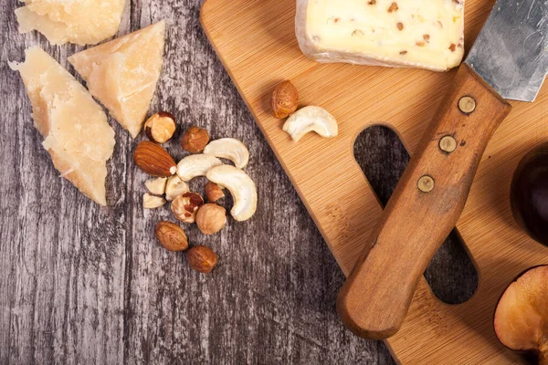 stock image Cheese, nuts and fruits on wooden background in studio photo