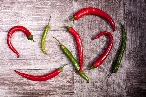 Spicy pepper on wooden background. Over top view. Chilli and hot