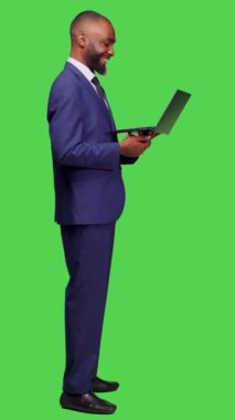 Dikey video: Uzaktan telekonferans sohbetlerinde dizüstü bilgisayarla konuşan Afro-Amerikan bir adamın bilgisayar konferansındaki profili. Takım elbiseli genç işletmeci insanlarla konuşuyor.