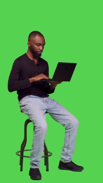 Вертикальне Відео Вид Збоку Чоловічої Моделі Працює Ноутбуком Зеленому Екрані — стокове відео