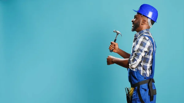 アフリカ系アメリカ人の大工は 改装や復興作業のための手動機器を使用して ハンマーで壁を打つ ジャックハンマーマレットツールを保持全体の男性コンストラクタ — ストック写真