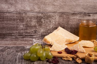 Peynir, bal, üzüm ve fındık studio fotoğraf ahşap arka plan üzerinde farklı tip