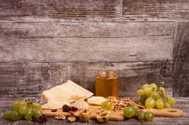Peynir, bal, üzüm ve fındık studio fotoğraf ahşap arka plan üzerinde farklı tip