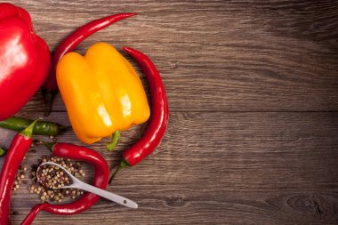 Ahşap arka plan üzerinde üstten görünüm chili, tatlı biber ve baharatlı biber. Baharatlı sağlıklı yaşam tarzı