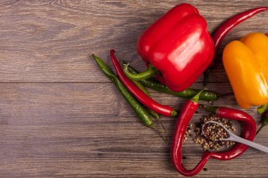 Ahşap arka plan üzerinde üstten görünüm chili, tatlı biber ve baharatlı biber. Baharatlı sağlıklı yaşam tarzı