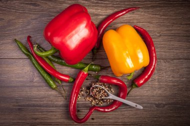 Ahşap arka plan üzerinde üstten görünüm chili, tatlı biber ve baharatlı biber. Baharatlı sağlıklı yaşam tarzı